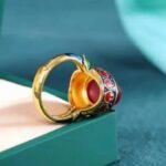 Adjustable ring featuring gold-sand plating, stone inlay, and enamel detailing.